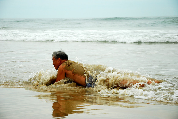 Een Koreaanse man speels in het zeewater